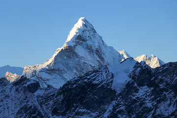 View of Ama Dablam mountain peak covered with snow and ice in Himalayas at sunrise from the summit...
