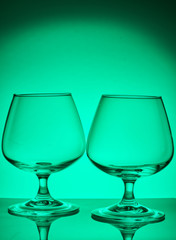 Two glass glasses on a colored background