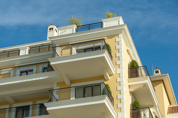 Obraz premium Tivat, Montenegro, December 16, 2019: Facade of the building of the Regent hotel on the Tivat embankment. The walls of the building are light yellow in the background of a blue sky