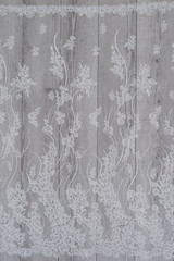 Fototapeta premium White wooden background with white spring flowers roses and lace ribbon. Happy womans day. The texture of lace on wooden background.