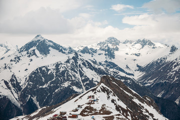 Views of high snow-capped mountain peaks are covered with fluffy white clouds