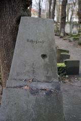 An einem Baum gekippter jüdischer Grabstein mit deutscher Inschrift
