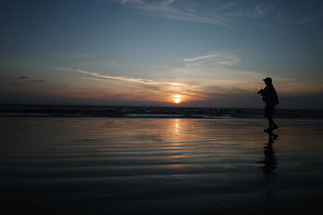 A man photographs the sunset. 
