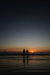 Fototapeta premium Two friends fish together at sunset. 
