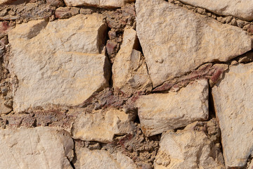 Background of limestone masonry. The surface is decorated with natural material. The wall is made of wild stone.
