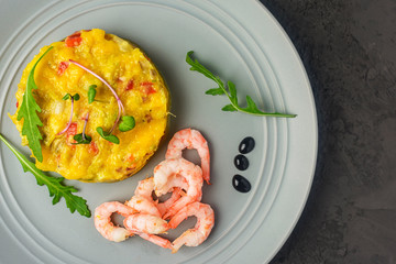 The chutney is neatly laid out on a gray plate. Near fresh shrimp. Delicious mango sauce with hot chili peppers.