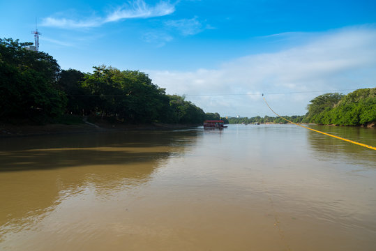 Sinu River in the city of Monteria with a transport boat for people driven by the river current. Colombia.