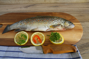 Fresh trout with spices and seasoning on cutting board