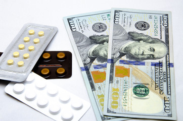 Fototapeta premium Hundred dollars in denominations and around a plate with pills. Drugs and dollars on a white background. Macro. Bribe. Hand gives money