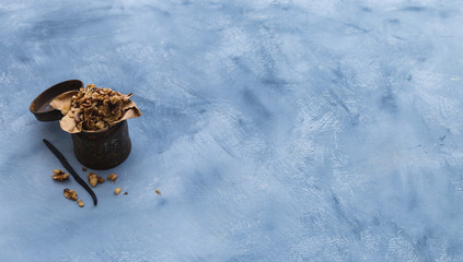 Walnuts in a rusty can on a grunge grey tabletop. Flat lay scenery with dried walnuts. Healthy vegan snack with vanilla stick. Copy space.