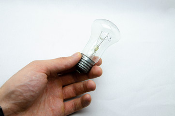 Ilyich bulb, incandescent lamp on a white and black background. In men's hands. Macro