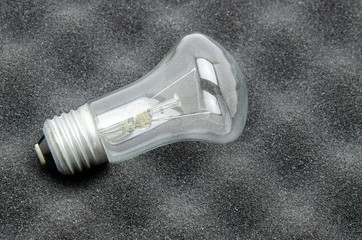 Ilyich bulb, incandescent lamp on a white and black background. In men's hands. Macro