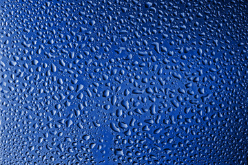Misted glass, drops close-up on a rainbow background. The image is tinted in the color of the year-classic blue.