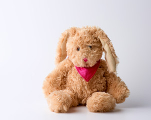 toy brown plush hare sitting on a white background