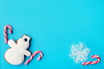 Blue festive background with snowman and canes