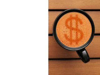 Black coffee mug on a wooden table. Art sign dollar on the foam, White copy space for text. Top view. Warm tones.