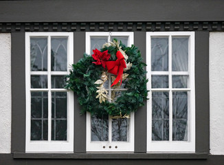 old fashioned wooden casement window decorated with Christmas wreath