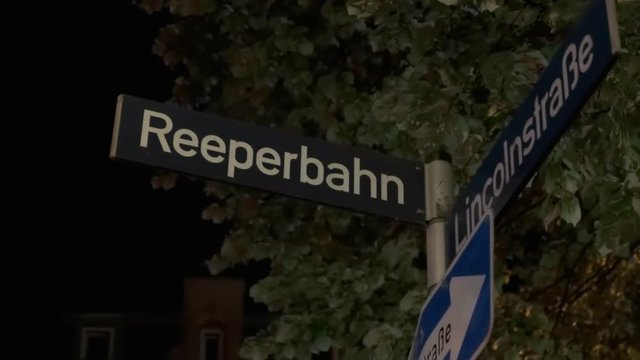 Reeperbahn street sign in night illumination and reflection of a siren from a passing patrol police car Hamburg Germany