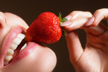 Woman smiling. Beautiful woman smiling with strawberry. Closeup of smile with white healthy teeth.