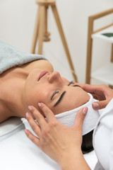 Fototapeta Odprężona kobieta podczas zabiegu w salonie kosmetycznym. Masaż limfatyczny twarzy.  obraz