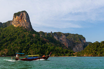 Thai long boat near Krabi Railay Beach beside limestone cliffs