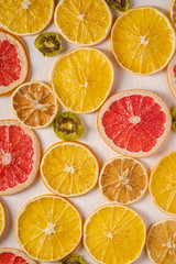 Fototapeta na wymiar Creative food fruit texture with dried grapefruit, orange, kiwi and lemon on white background, top view