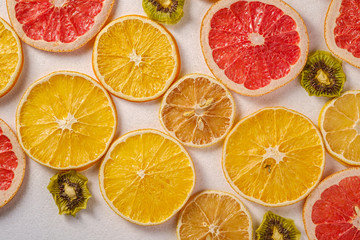 Fototapeta na wymiar Creative food fruit texture with dried grapefruit, orange, kiwi and lemon on white background, top view