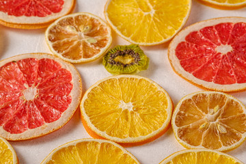 Creative food fruit texture with dried grapefruit, orange, kiwi and lemon on white background, angle view