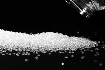 Transparent polypropylene granules plastic pellets material on black background