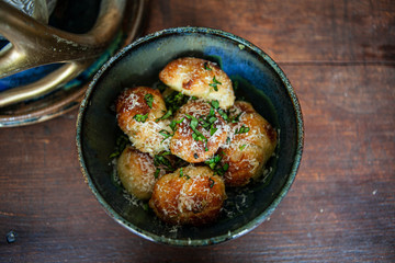 Homemade garlic knots in a glazed rustic bowl