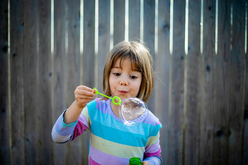 girl is excited by big bubble in back yard