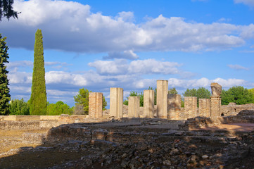Old white columns and ruined square in ancient roman city Italica, Sevile, Spain