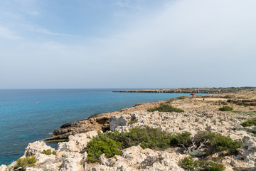 Fototapeta na wymiar Curved rocky seashore and transparent water of Mediterranean sea