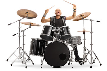 Male musician in leather vest playing a drum kit