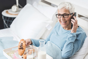 Senior woman having breakfast in bed