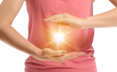 Meditating woman with ball of shining energy on white background