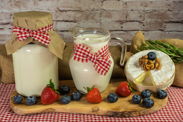 Milk in a jug, dairy produce, composition of milk, cheese, nuts  and berries