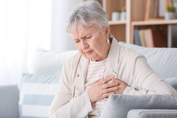 Senior woman suffering from heart attack at home