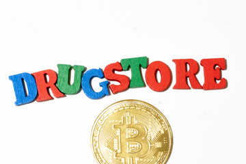 Top view of word drugstore and bitcoin on white background. Cryptocurrency concept
