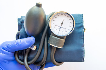 Medical professional, nurse or doctor holds in hand, wearing blue medical glove, blood pressure...