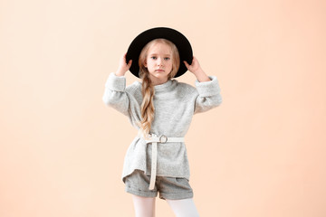 Cute little girl in autumn clothes on light background