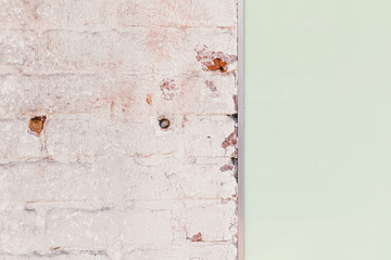 Distressed rusty cracked white wall next to smooth green wall background texture