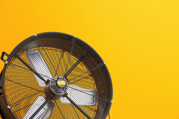 Electric fan on color background
