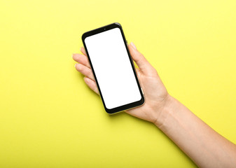 Female hand with mobile phone on color background