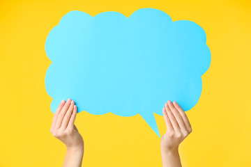 Female hands with blank speech bubble on color background