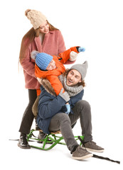 Happy family in winter clothes and with sledges on white background