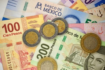 Mexican pesos bills spread randomly over a flat surface
