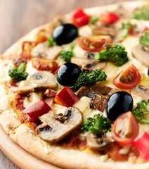 Healthy pizza with broccoli, cherry tomatoes, red pepper and champignon mushrooms. Close up. 