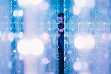 photographer taking a picture through walls of bright LED string lights 