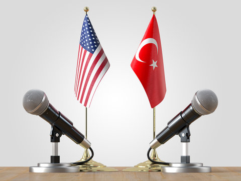 Microphones and  flags pair on a desk over isolated background.3d illustration
